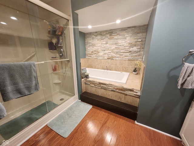 bathroom featuring independent shower and bath and wood-type flooring