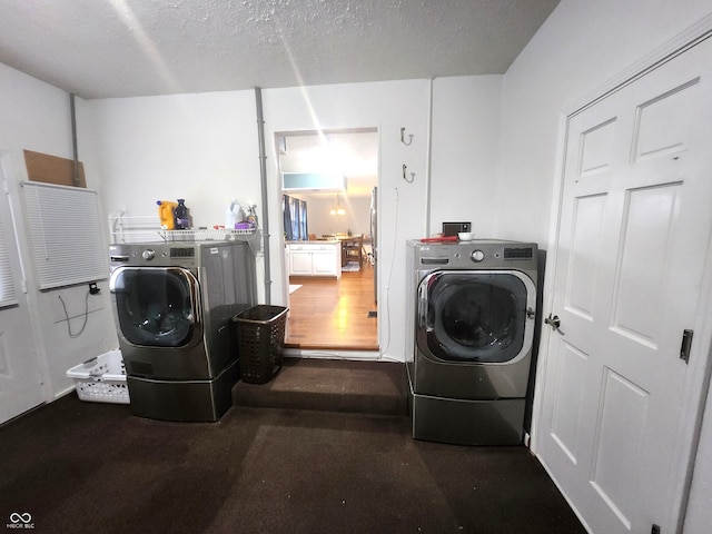 washroom with washer and dryer and a textured ceiling