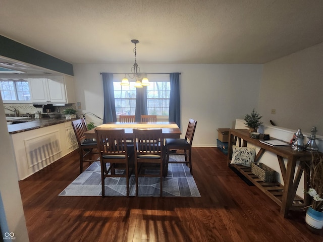 dining area featuring dark wood-type flooring and a notable chandelier