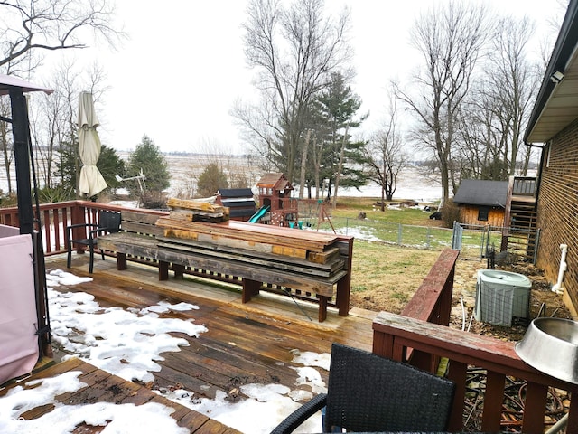 snow covered deck featuring central AC and a playground