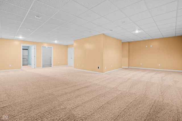 carpeted empty room featuring a drop ceiling