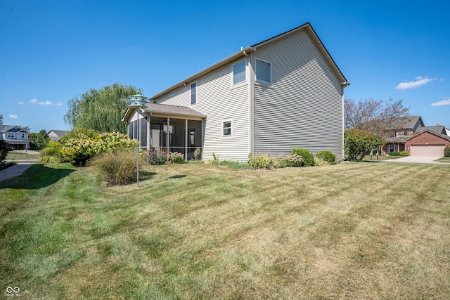 back of house featuring a yard and a sunroom