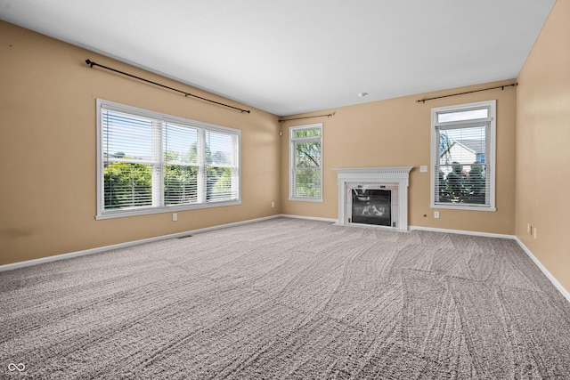 unfurnished living room with plenty of natural light and carpet flooring