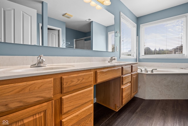 bathroom with vanity, independent shower and bath, and hardwood / wood-style floors