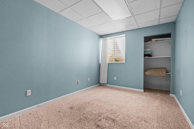 unfurnished bedroom featuring a paneled ceiling and carpet flooring