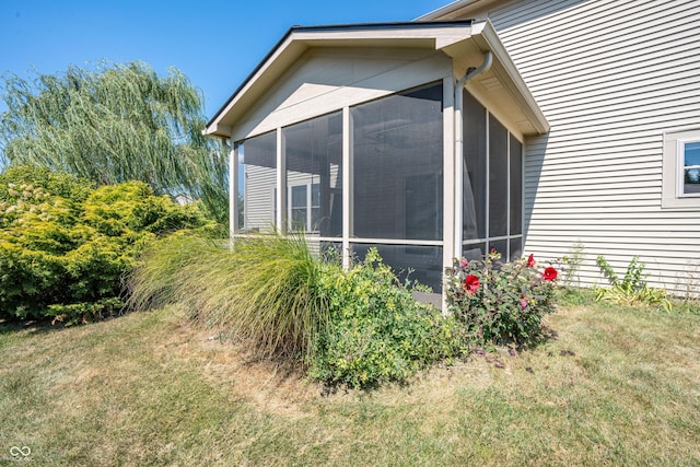 view of side of property featuring a yard and a sunroom