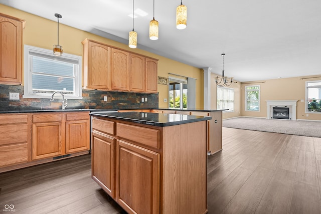 kitchen with tasteful backsplash, hanging light fixtures, and a kitchen island