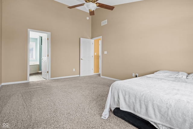 carpeted bedroom featuring high vaulted ceiling, ceiling fan, and ensuite bathroom