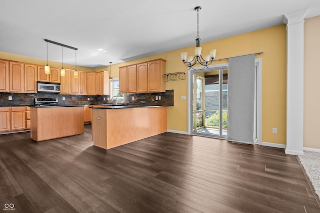 kitchen with stainless steel appliances, a center island, a wealth of natural light, and decorative light fixtures