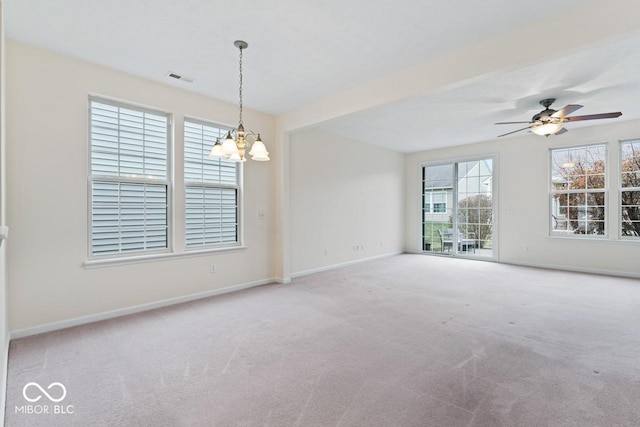 unfurnished room with carpet flooring and ceiling fan with notable chandelier