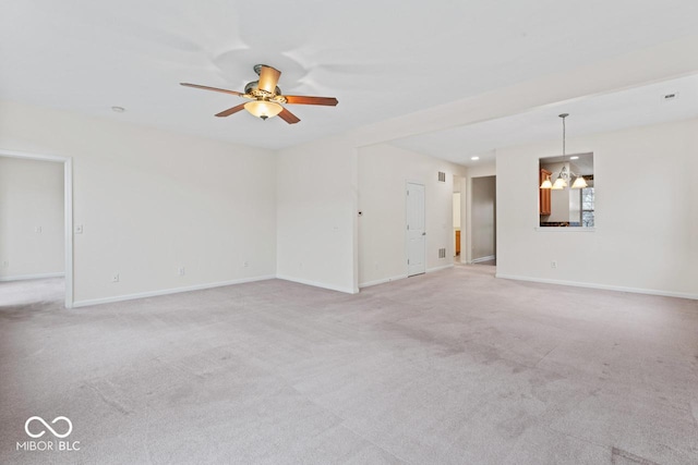 unfurnished room with light carpet and ceiling fan with notable chandelier