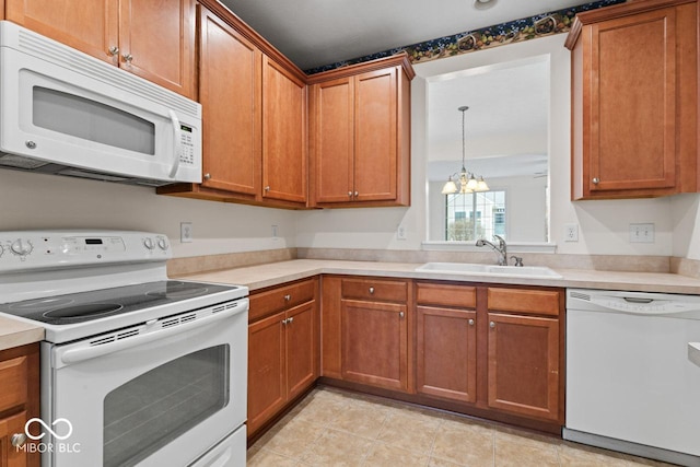 kitchen featuring light tile patterned flooring, sink, a notable chandelier, and white appliances