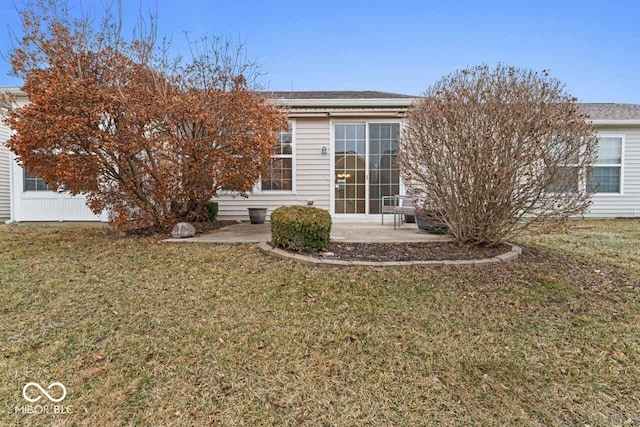 back of property with a patio and a lawn