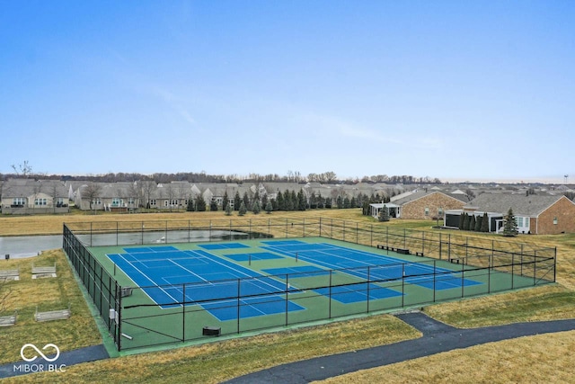 view of tennis court featuring a lawn