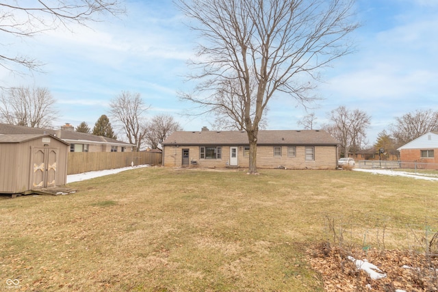 rear view of house with a yard and a storage shed