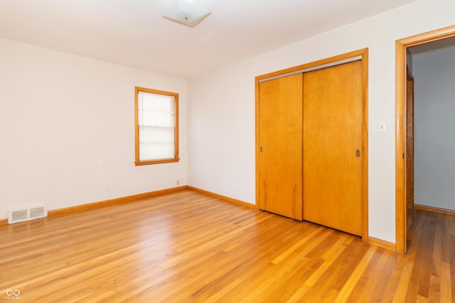 unfurnished bedroom with light hardwood / wood-style floors and a closet