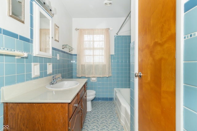 full bathroom with tile walls, vanity, tub / shower combination, and toilet