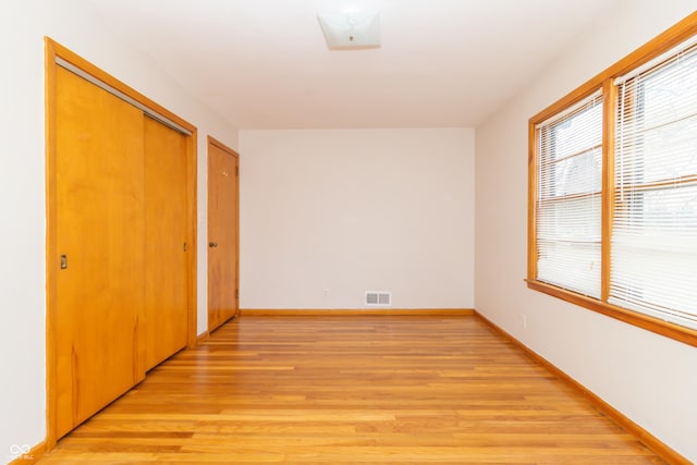 unfurnished bedroom featuring light hardwood / wood-style floors and a closet