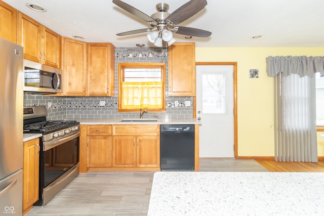 kitchen with tasteful backsplash, sink, stainless steel appliances, and ceiling fan