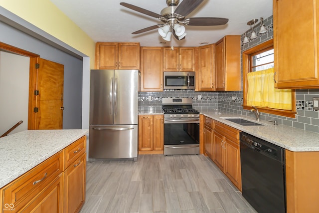 kitchen with sink, ceiling fan, stainless steel appliances, light stone countertops, and decorative backsplash