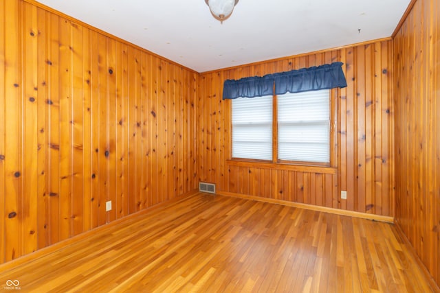 empty room with wood-type flooring and wood walls