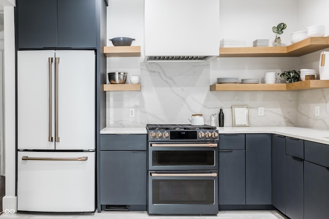 kitchen with tasteful backsplash, high end white refrigerator, double oven range, and blue cabinets