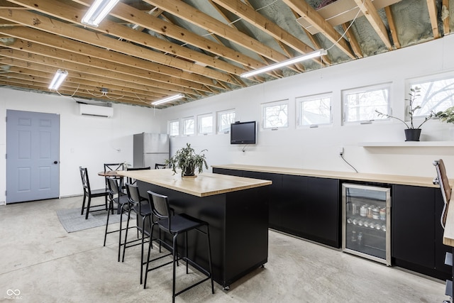 bar with an AC wall unit, beverage cooler, a healthy amount of sunlight, and white fridge