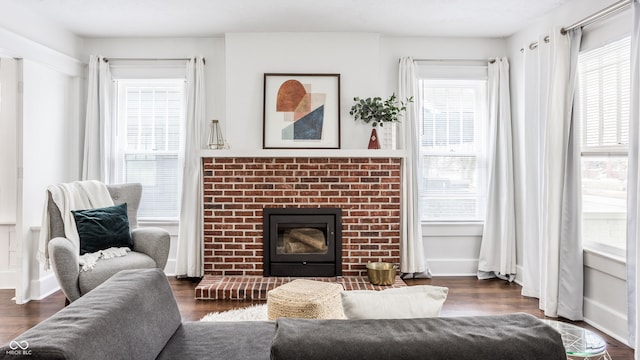 living room with a brick fireplace and dark hardwood / wood-style floors