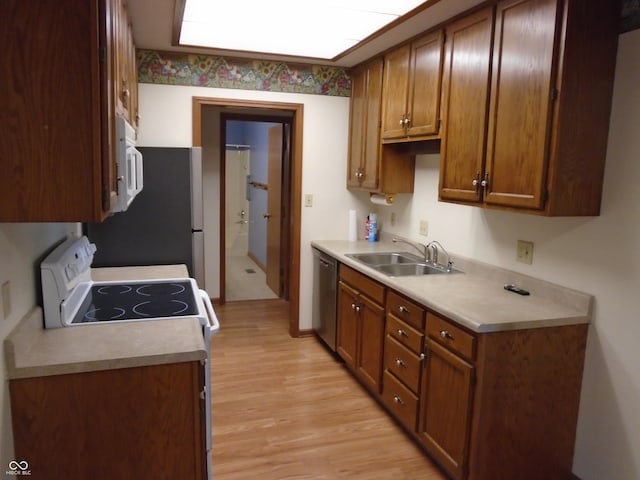 kitchen featuring sink, white appliances, and light hardwood / wood-style floors