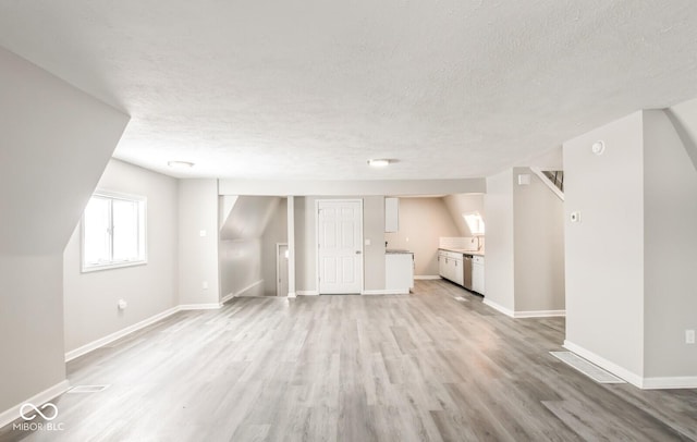 interior space featuring light hardwood / wood-style floors and a textured ceiling