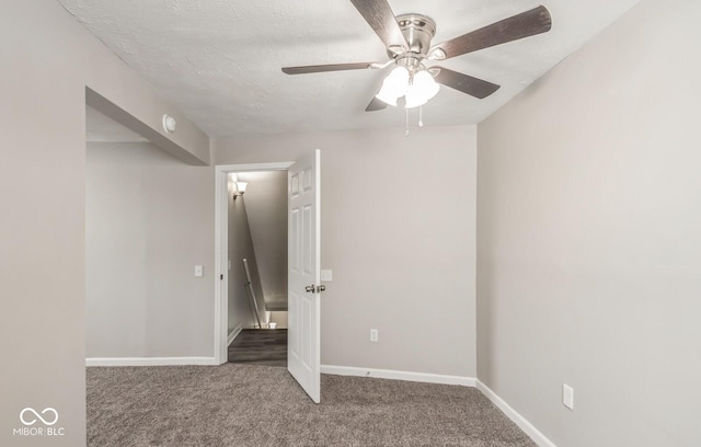 unfurnished bedroom featuring ceiling fan, carpet floors, and a textured ceiling