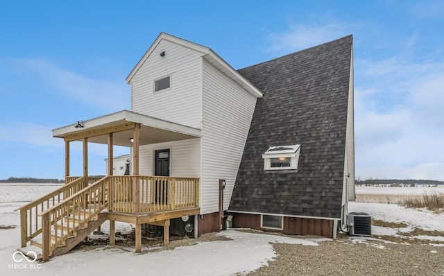 snow covered property featuring cooling unit and covered porch