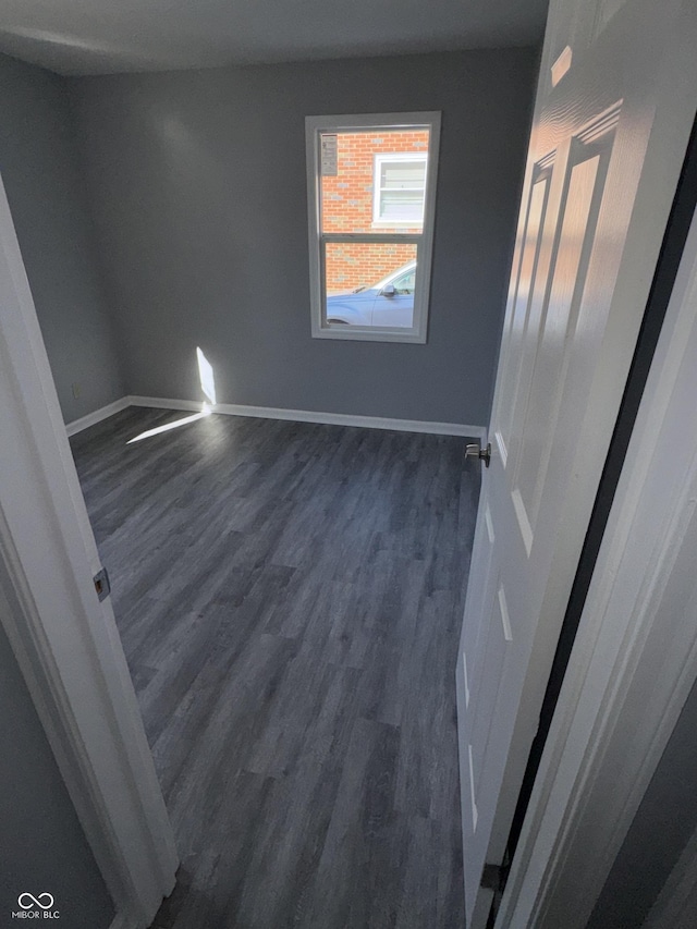 unfurnished room with dark wood-type flooring