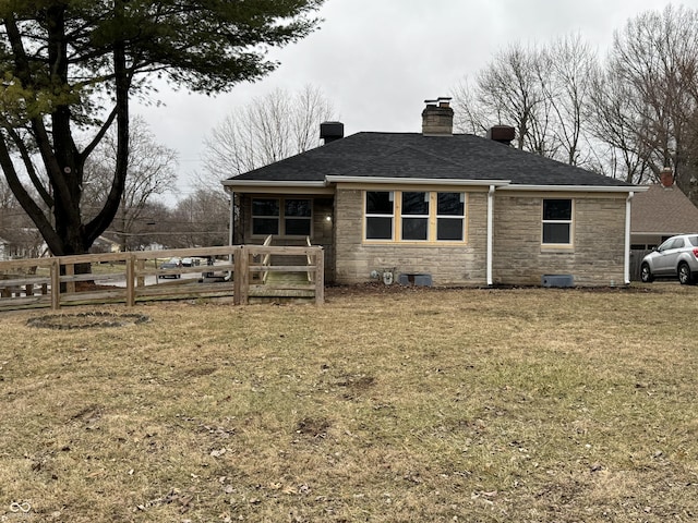 rear view of property featuring a yard