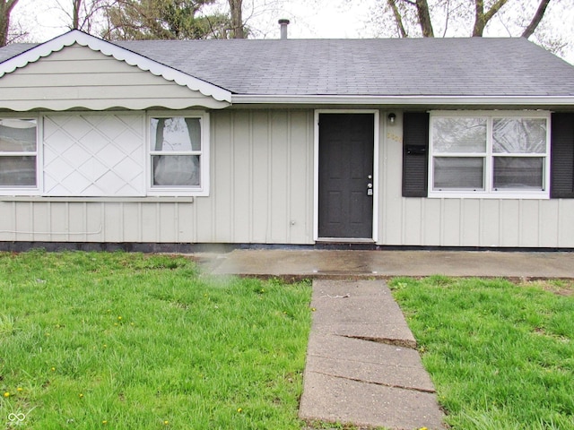 view of exterior entry featuring a lawn