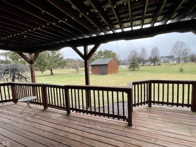 wooden terrace featuring a shed and a yard