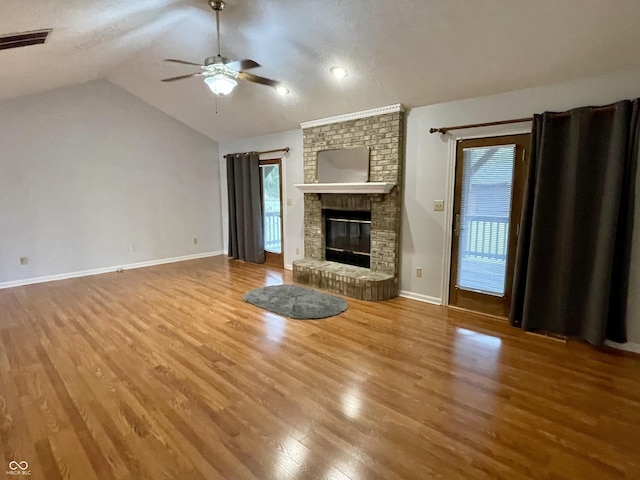 unfurnished living room featuring a brick fireplace, vaulted ceiling, hardwood / wood-style floors, and ceiling fan