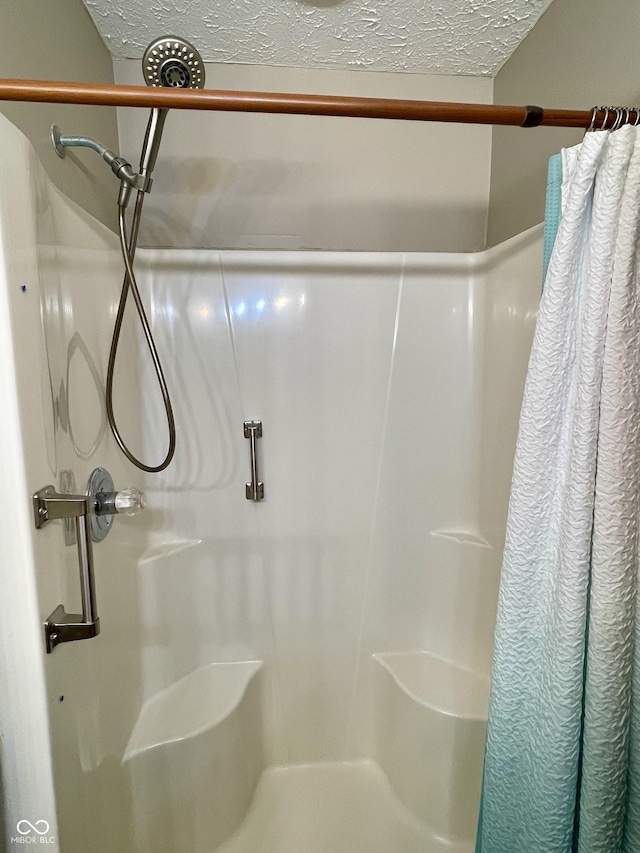 bathroom with a shower with curtain and a textured ceiling