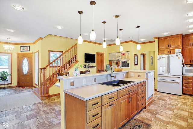 kitchen with sink, hanging light fixtures, ornamental molding, a kitchen island with sink, and white appliances