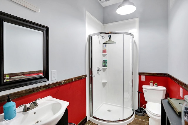 bathroom featuring toilet, sink, tile patterned floors, and walk in shower