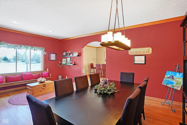 dining area featuring ornamental molding, hardwood / wood-style floors, and a textured ceiling