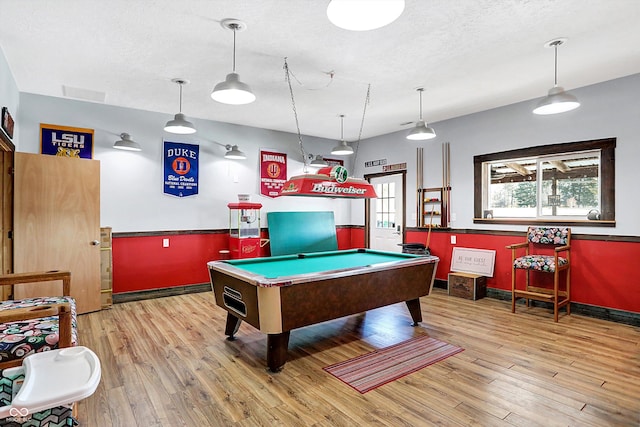 recreation room featuring a textured ceiling, light wood-type flooring, and billiards