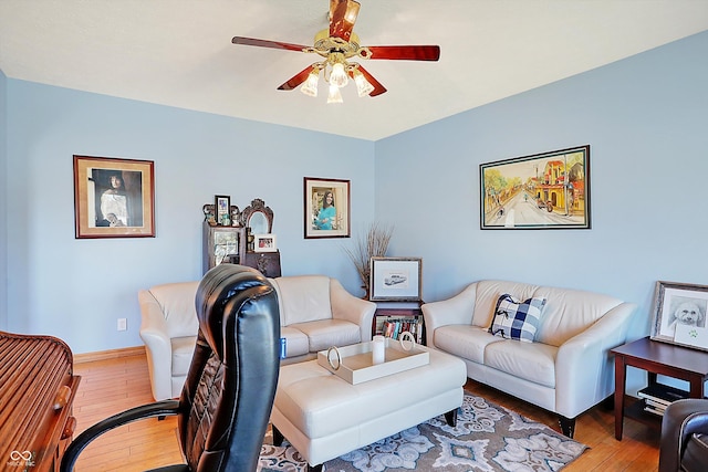 living room featuring wood-type flooring and ceiling fan