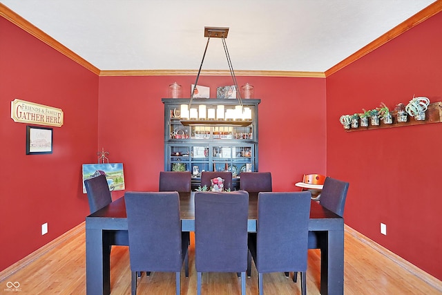 dining room with ornamental molding and wood-type flooring