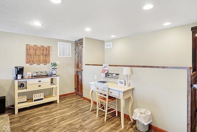 home office featuring hardwood / wood-style flooring and a textured ceiling