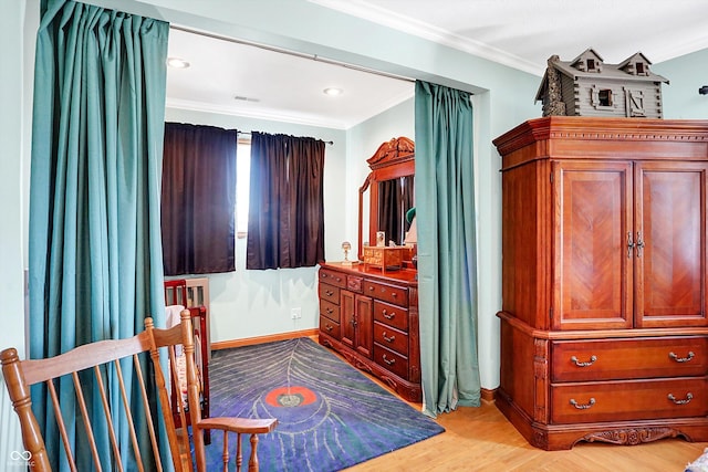 bedroom featuring ornamental molding and light wood-type flooring