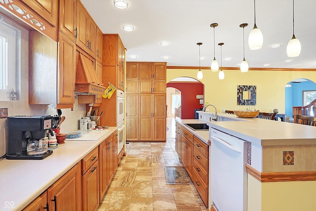 kitchen featuring premium range hood, pendant lighting, sink, a center island with sink, and white appliances