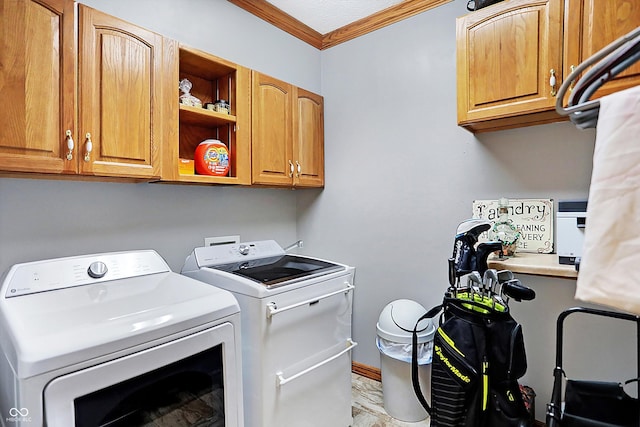 laundry room featuring cabinets, washing machine and clothes dryer, and ornamental molding