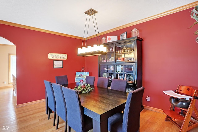 dining area featuring an inviting chandelier, ornamental molding, and light hardwood / wood-style floors