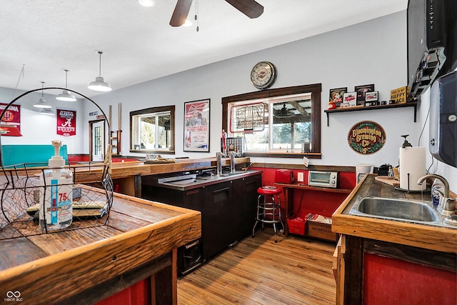 kitchen with ceiling fan, sink, and light wood-type flooring